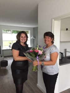 Ilse Hilbink, links op de foto, ontvangt bloemen van Janet Kroezen